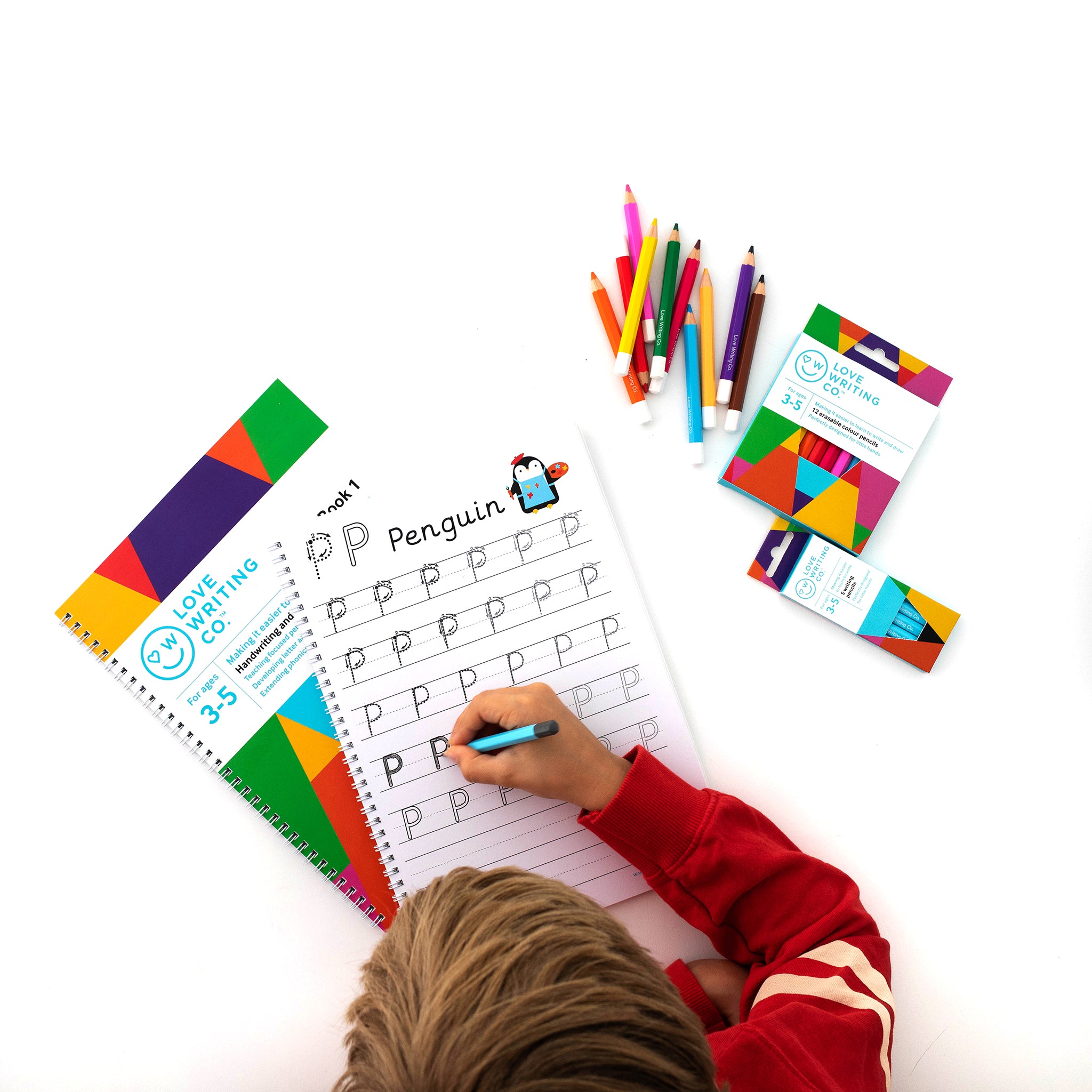 Child from above using activity pack and pencils to draw and learn to write
