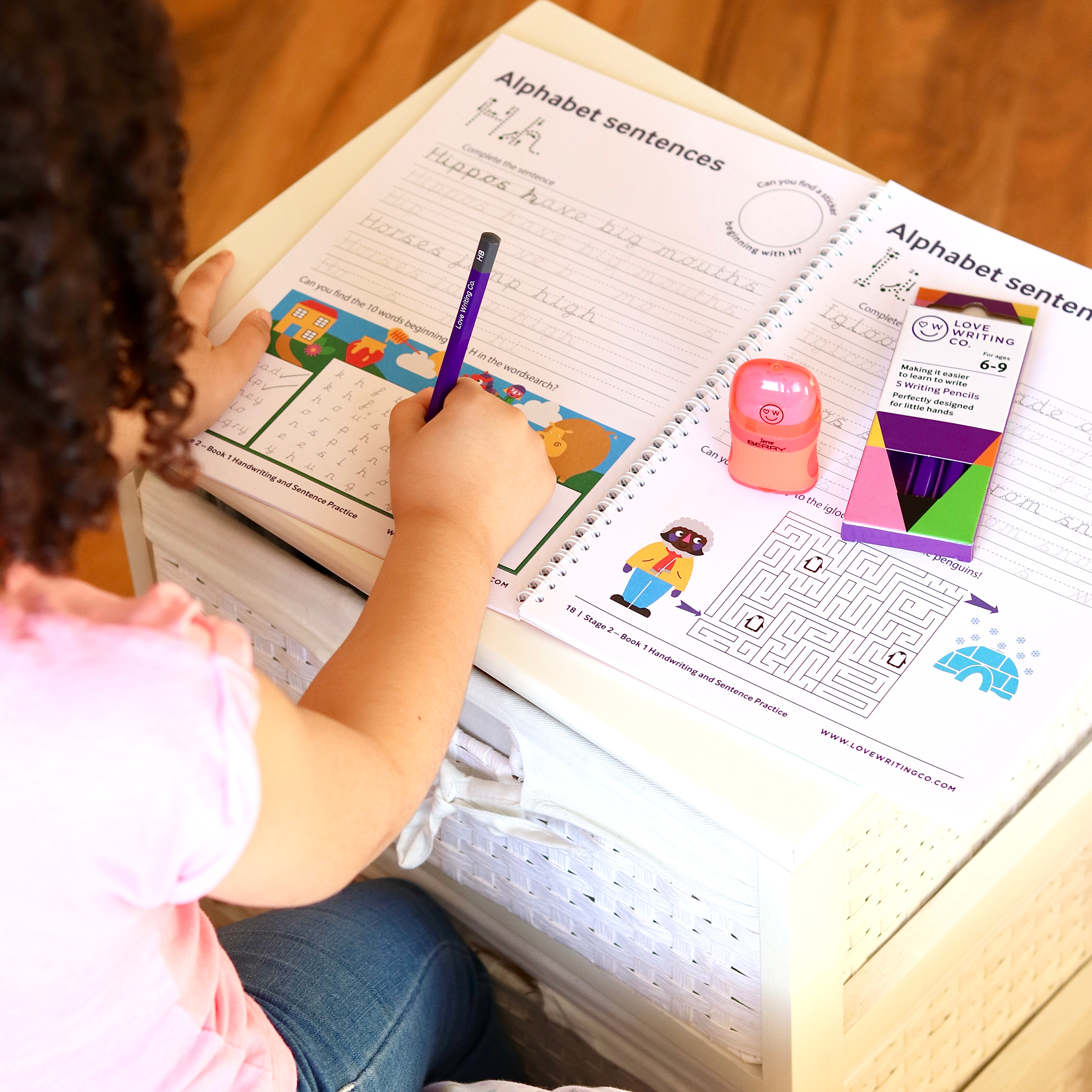 A child doing tracing activities on Love Writing Cos workbook