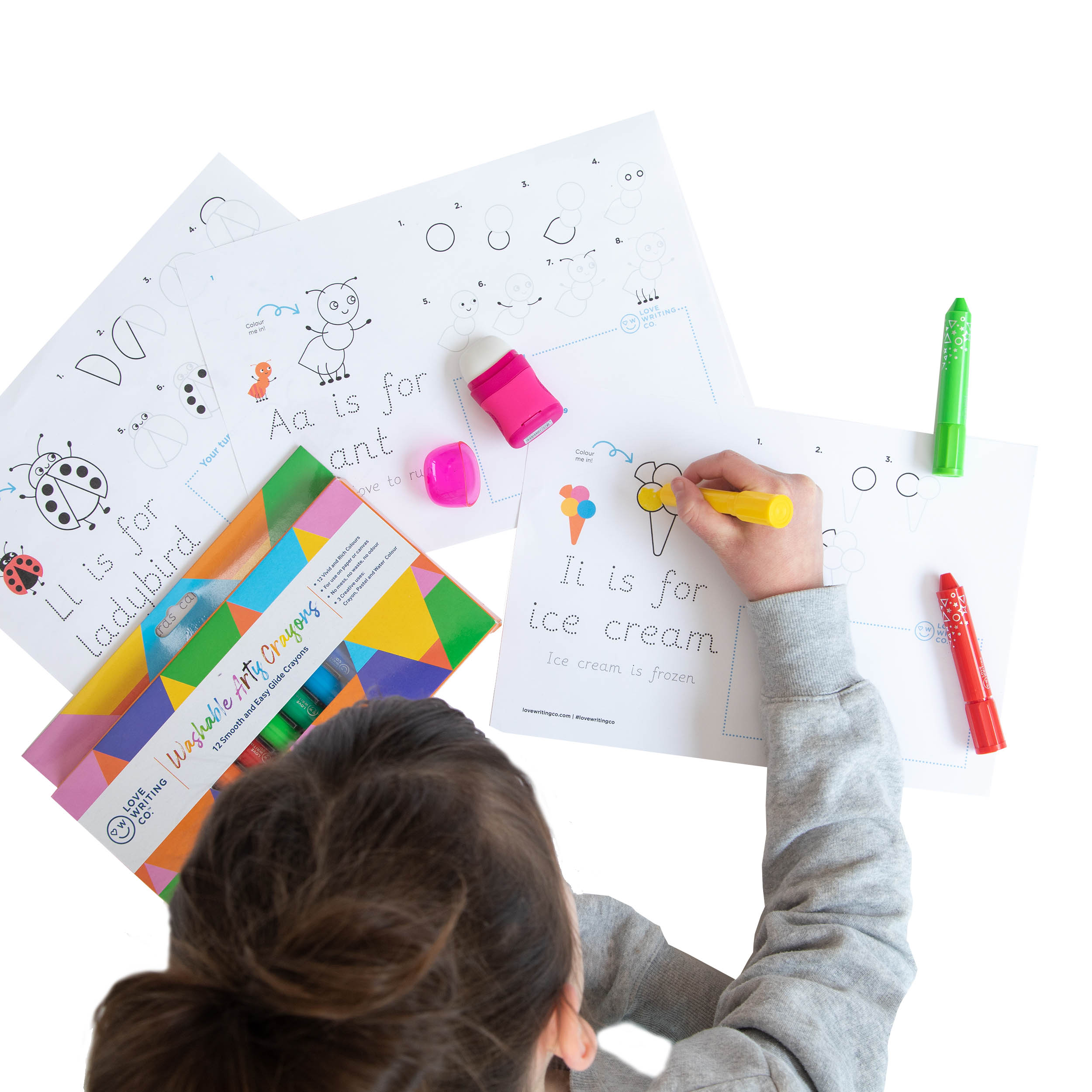 A young girl using Love Writing Co's washable crayons to color greeting cards